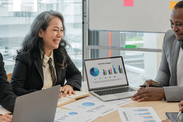 Multiracial diverse businesspeople brainstorm work together on paperwork at team meeting in office. Concentrated multiethnic colleagues discuss business ideas. Teamwork concept