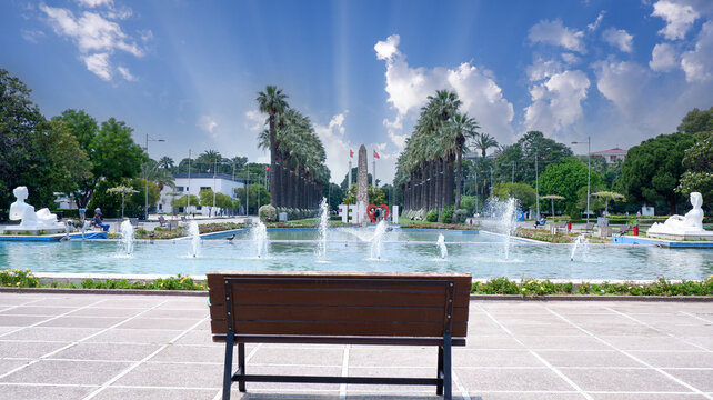 Izmir Alsancak Fuar, palm tree background, beautiful blue sky, bench in the park, fair, free bench in front of the pool