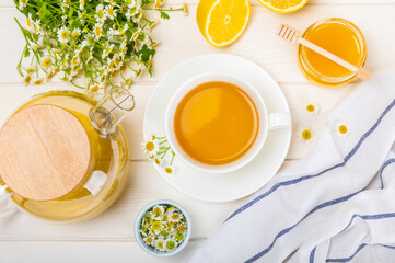 Herbal tea with fresh chamomile flowers on textured background. Calming and relaxing drink. Immunity.Cup of hot chamomile tea. Tea drinking concept. Tea ceremony. Place for text, copy space.