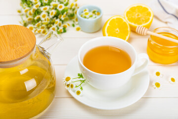 Herbal tea with fresh chamomile flowers on textured background. Calming and relaxing drink. Immunity.Cup of hot chamomile tea. Tea drinking concept. Tea ceremony. Place for text, copy space.