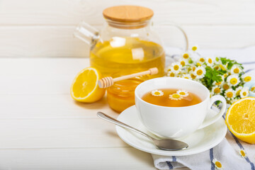 Herbal tea with fresh chamomile flowers on textured background. Calming and relaxing drink. Immunity.Cup of hot chamomile tea. Tea drinking concept. Tea ceremony. Place for text, copy space.
