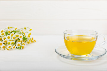 Herbal tea with fresh chamomile flowers on textured background. Calming and relaxing drink. Immunity.Cup of hot chamomile tea. Tea drinking concept. Tea ceremony. Place for text, copy space.