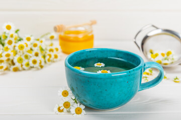 Herbal tea with fresh chamomile flowers on textured background. Calming and relaxing drink. Immunity.Cup of hot chamomile tea. Tea drinking concept. Tea ceremony. Place for text, copy space.