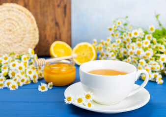 Herbal tea with fresh chamomile flowers on textured background. Calming and relaxing drink. Immunity.Cup of hot chamomile tea. Tea drinking concept. Tea ceremony. Place for text, copy space.