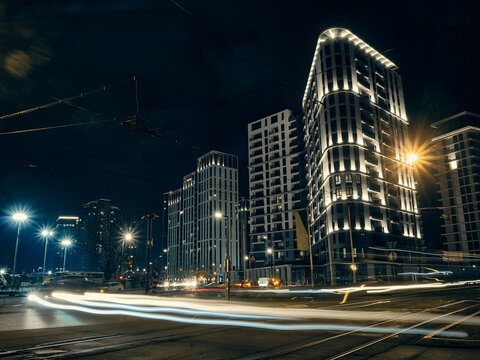 Low angle view of traffic on night city street. Light trails of cars driving by on street and night city illumination captured with long exposure. Belgrade, Serbia