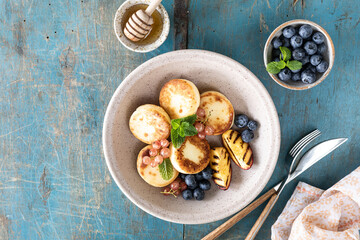 Cottage cheese pancakes, cheesecakes, ricotta fritters with fresh blueberries, currants and peaches