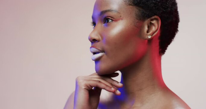 African american woman with short dark hair in blue and pink light with copy space, slow motion