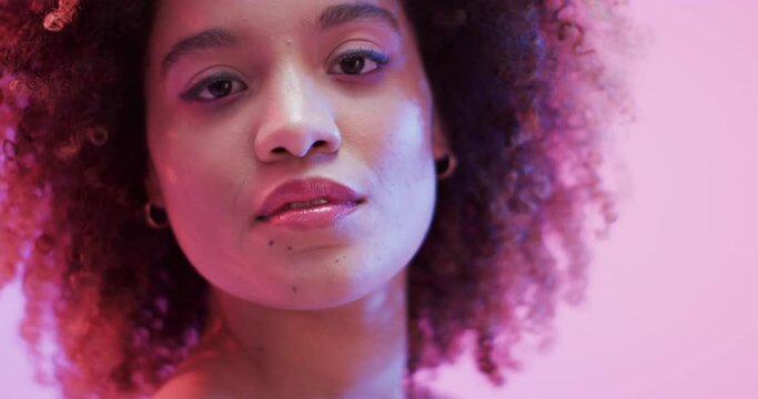 Biracial woman with dark hair in blue and pink light, slow motion