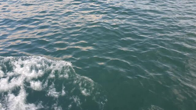 Water surface with waves and ripples from a moving boat.