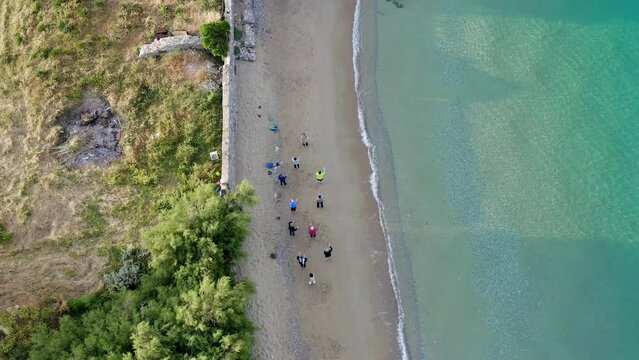 Aerial View Of Group Of People Doing Yoga On The Beach.