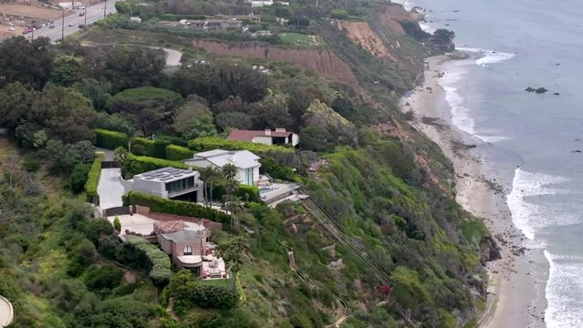 Zuma Beach by Point Dume and Malibu mansions of the rich and famous - aerial parallax