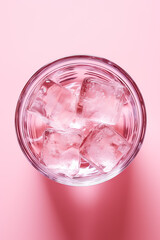 Top view of glass of water with ice on pink background isolated 