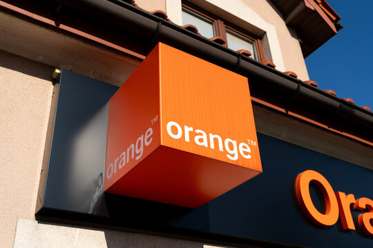 Orange company logo sign. Telecommunications provider signboard with brand logotype at entrance to branch office building on August 14, 2023 in Niepolomice, Poland.