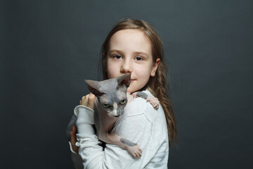 Cheerful kid girl with cat on blue background