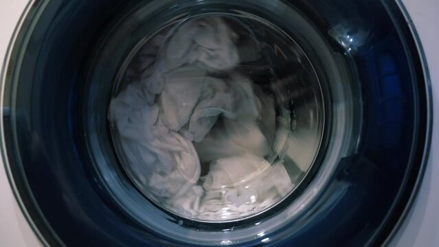 The movement of laundry when drying in the washing machine. Wet things in the drum of the washing machine. High quality 4k footage