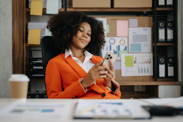 African Businesswoman using mobile phone, tablet. on blurred background..