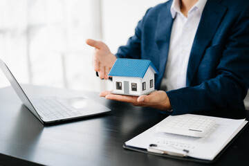 Buying a home or insurance deal, an insurance agent pointing a pen to those interested in renting a house, a contract, signing an Home buying agreement in office.