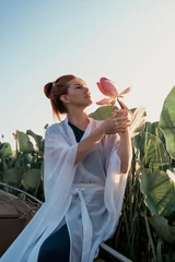 Küchenrückwand glas motiv A red-haired girl in a white coat on a boat in lotus flowers on the Volga sand in the summer of 2023 © Антонина Лунева