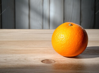 Orange on a wooden table, in the style of minimalist images.