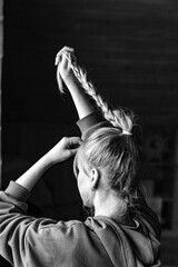 A young girl in a blue hoodie is messing with her braids on the eve of the new year