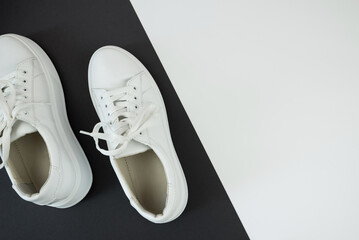 top view of white sneakers on black and white background