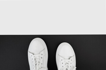 top view of white sneakers on black and white background