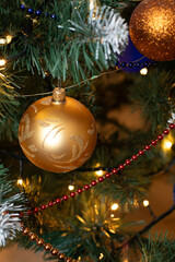 Golden baubles on christmas tree for background. New Year concept.