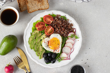 Healthy romantic breakfast - heart-shaped fried eggs served with avocado, spinach, quinoa, cherry tomatoes, radish and black olives, Top view