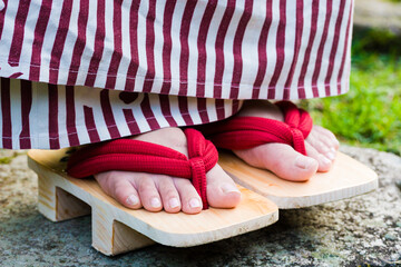 Close-up of Geta shoes and woman toes, traditional japanese female wooden footwear, Kurokawa Onsen, Japan - obrazy, fototapety, plakaty