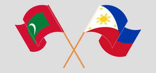 Crossed and waving flags of Maldives and the Philippines