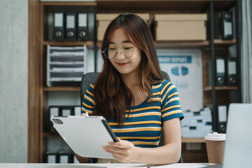 Fototapeta premium Women using tablet with laptop and document on desk in modern office.