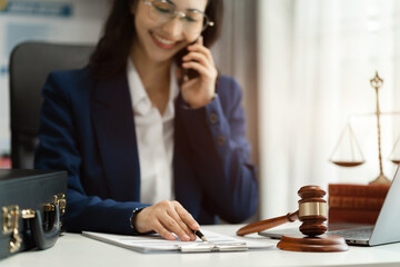Legal counsel talking mobile phone with legal advice  to the client a signed contract with legal. justice and lawyer concept in office.