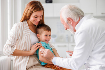 Mother holding child in lap for vaccination in hospital