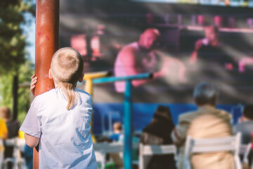 Boy on the playground watching a movie in the open air