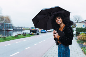 Happy woman waiting a taxi or bus in raining day.