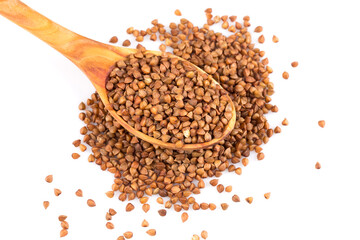 Uncooked buckwheat on wooden spoon