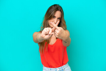 Young caucasian woman isolated on blue background making stop gesture with her hand to stop an act