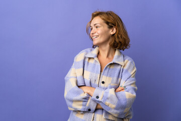 Young Georgian woman isolated on purple background with arms crossed and happy