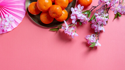 Chinese or lunar new year flat lay with paper decorations, mandarins and flowers on pink