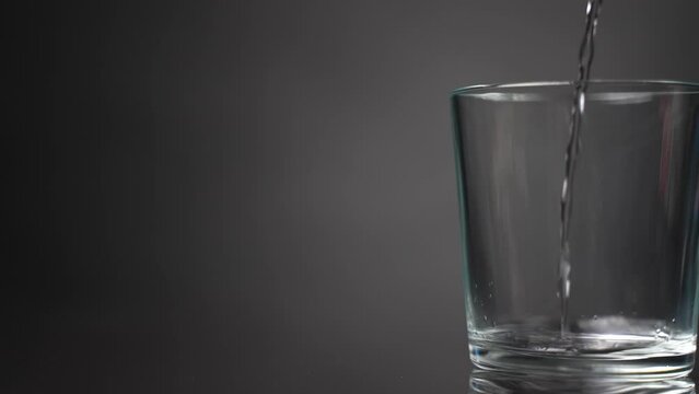 Pour water into a glass beaker. Slow motion