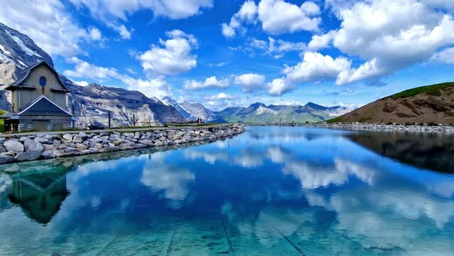 Red Jungfrau Railway Train Passing by Turquoise Fallboden Lake with Snowy Eiger and Jungfrau Peaks Reflections Bernese Alps Switzerland Cinematic 4K
