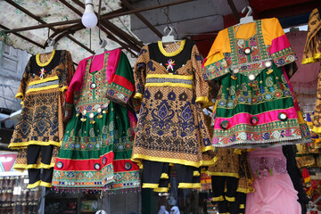 Traditional national dresses are on market in Peshawar city, Pakistan. Pashtun style. Pashtun fashion. Bazaar in Peshawar city, Pakistan. Pakistani fair, shop with folk dresses. Asian street market