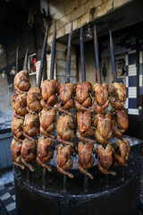 Fried chickens for sale on street market in Peshawar city, Pakistan. Pakistani street food. BBQ chicken, roasted whole chickens. Grill meat of chicken. Barbecue outdoor in Peshawar city, Pakistan