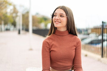 Fototapeta premium Teenager girl at outdoors With glasses with happy expression