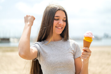 Teenager girl with a cornet ice cream at outdoors celebrating a victory