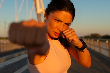 Woman shadow boxing with her hands wrapped on bridge