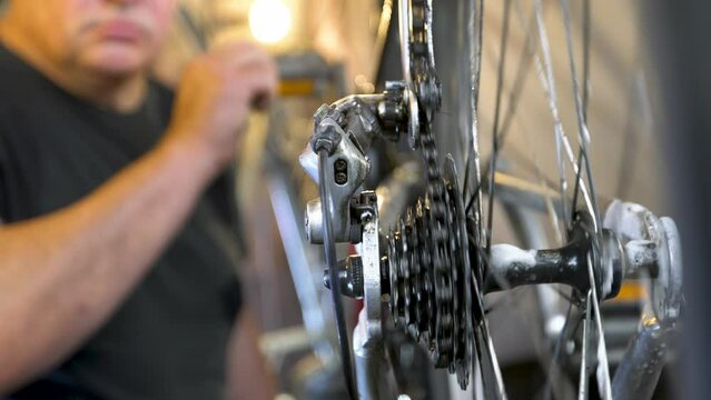 Bicycle mechanic in the workshop during the repair process records a video.