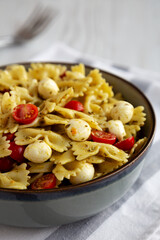 Homemade Pesto Pasta with Tomatoes ans Mozzarella in a Bowl, low angle view. Close-up.