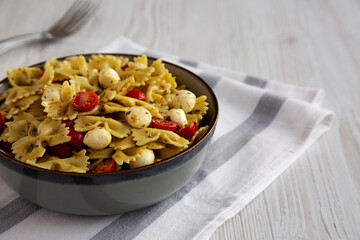 Homemade Pesto Pasta with Tomatoes ans Mozzarella in a Bowl, low angle view. Copy space.