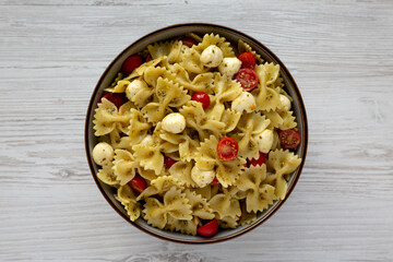 Homemade Pesto Pasta with Tomatoes and Mozzarella in a Bowl, top view. Flat lay, overhead, from above.
